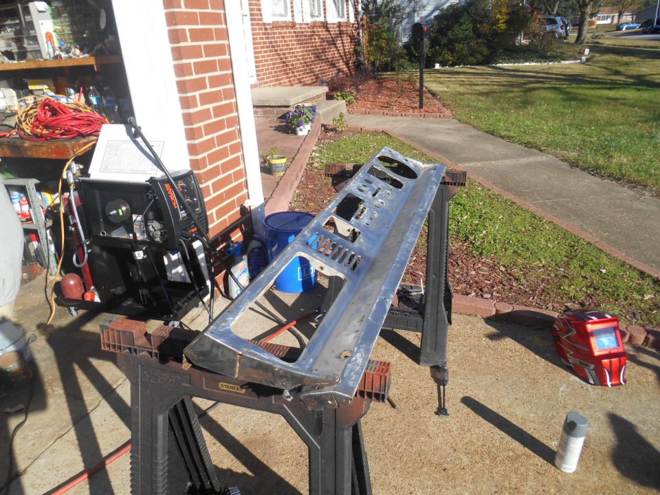 Silver dashboard panel with multiple cutouts resting on sawhorses