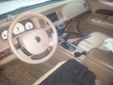 2000 Mercury Grand Marquis - The interior of a 2000 Mercury Grand Marquis is visible, wood trim and tan upholstery.
