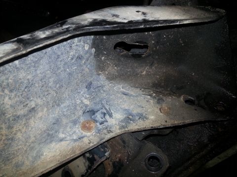 1994 Ford Bronco - Detail of a vehicle's undercarriage frame, showing signs of wear and corrosion.