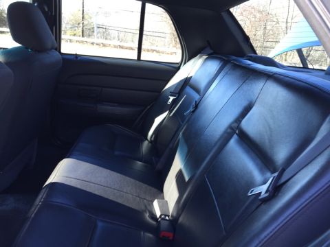 2001 Ford Crown Victoria - The interior of a car shows the back seat and door panel.