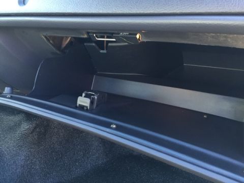 2001 Ford Crown Victoria - Interior view of an open glove compartment with a watch resting inside.