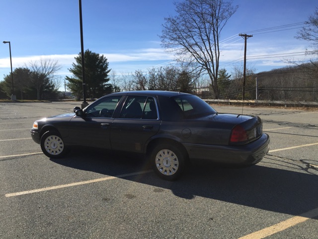 Dark gray 2001 Ford Crown Victoria parked in a lot.