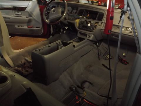 1999 Mercury Grand Marquis - The interior of a disassembled car, likely a sedan, shows the dashboard, center console, and front seats removed or partially dismantled. W…