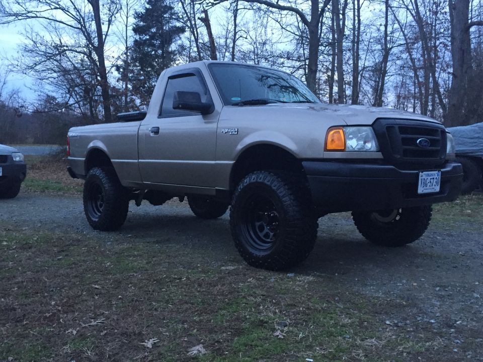 Tan Ford Ranger pickup truck with lifted suspension and off-road tires.