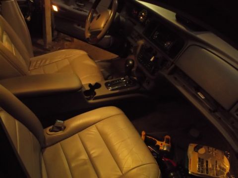 1999 Mercury Grand Marquis - The interior of a car, likely a 1999 Mercury Grand Marquis, is shown from the passenger side looking towards the driver. The tan leather se…