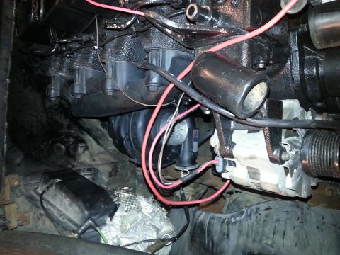 1994 Ford Bronco - Close-up view of the engine bay of a 1994 Ford Bronco, showing various engine components, wiring, and the alternator.