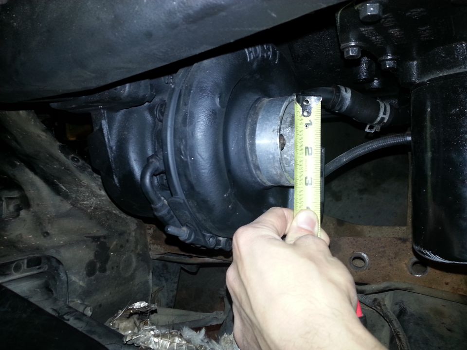 Measuring turbocharger diameter with a tape measure.