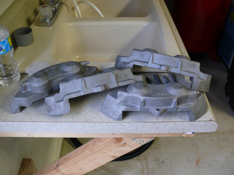 Two unpainted cast iron brake calipers on a countertop.