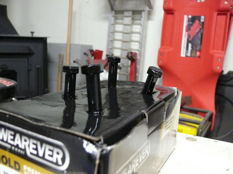 Four black bolts sticking out of a box with "WEAR EVER" text.