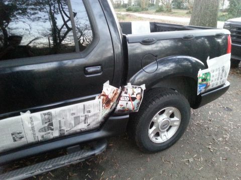 2001 Ford Explorer - The side of a black Ford Explorer Sport Trac is shown, with newspaper and Star Wars-themed posters taped to the lower body panels and bed.…