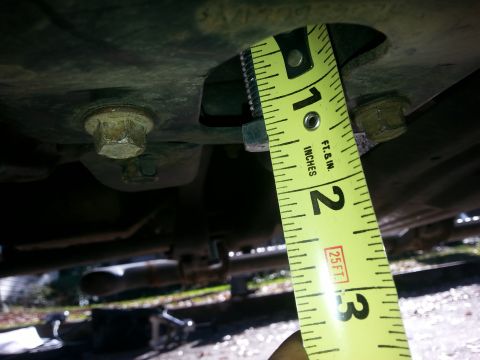 2001 Ford Explorer - A yellow measuring tape is shown against the underside of a vehicle, measuring a gap between two metal components. The tape indicates a mea…