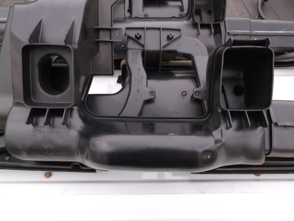 Black plastic automotive HVAC ducting assembly with visible part numbers.