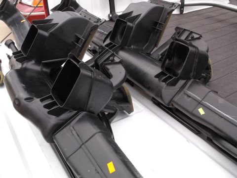 1999 Mercury Grand Marquis - Two black plastic HVAC ducting assemblies are shown laid out on a white surface, possibly a truck bed. The parts are complex with multiple…