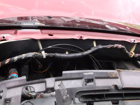 1999 Mercury Grand Marquis - The image shows a close-up view of a vehicle's engine bay, focusing on a bundle of wires wrapped in black tape and secured with zip ties. V…