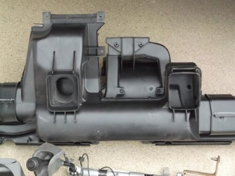 1999 Mercury Grand Marquis - A black plastic air intake manifold assembly is shown laid out horizontally against a speckled gray surface. The assembly features multiple…