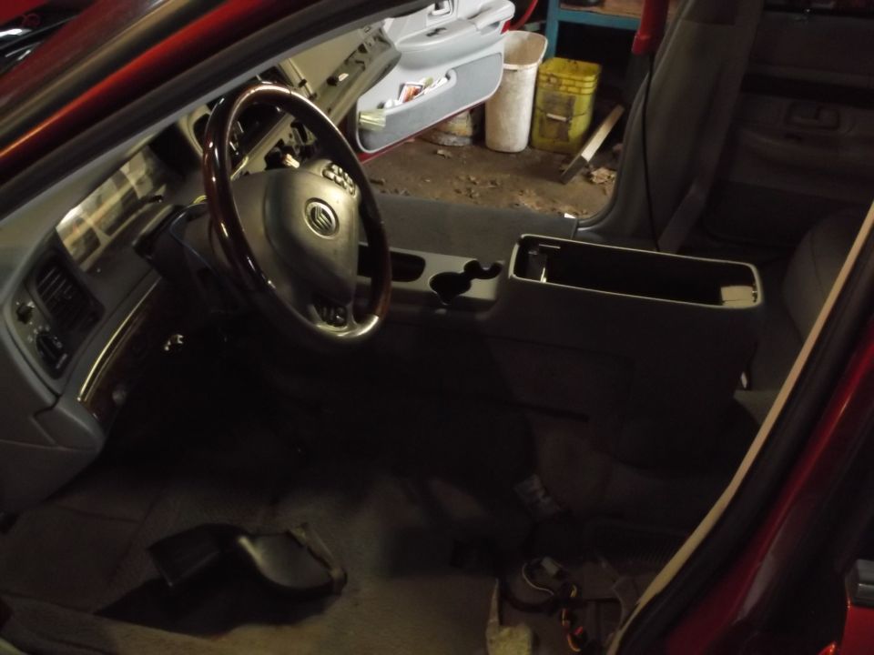 Interior of a red Mercury Grand Marquis, showing dashboard, steering wheel, and center console.