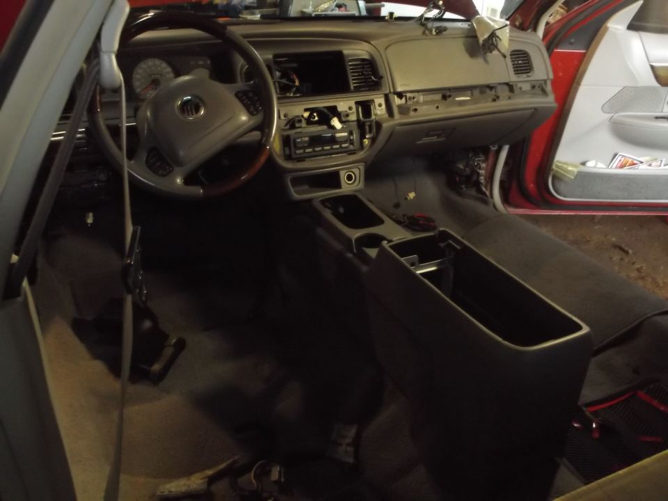 Interior of a Mercury Grand Marquis with dashboard and center console disassembled.