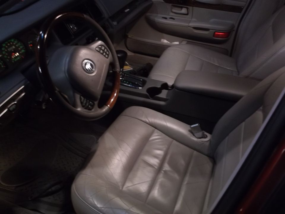 Interior of a car showing a steering wheel, driver's seat, and center console.