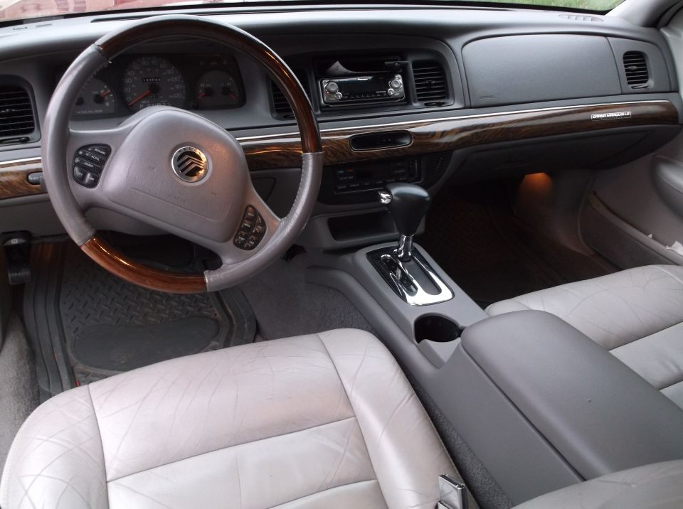 Interior of a 1999 Mercury Grand Marquis, showing steering wheel, dashboard, and seats.