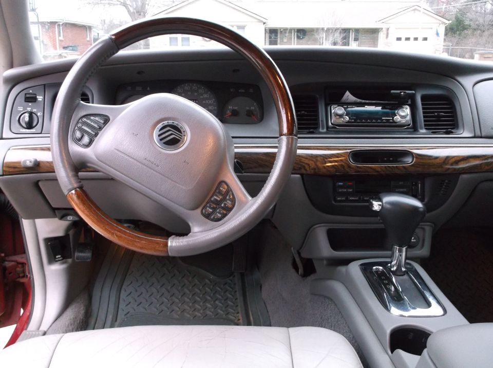1999 Mercury Grand Marquis interior with wood trim steering wheel, dashboard, and center console.