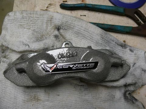 Corvette Stingray brake caliper with OL298 stamping on a white cloth.