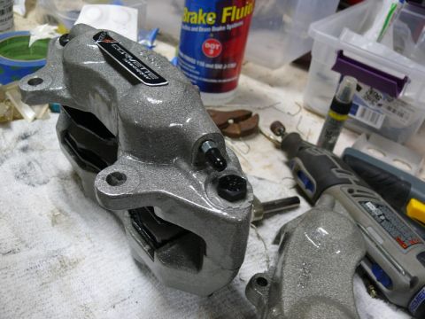 Corvette brake caliper with logo sticker and tools in background