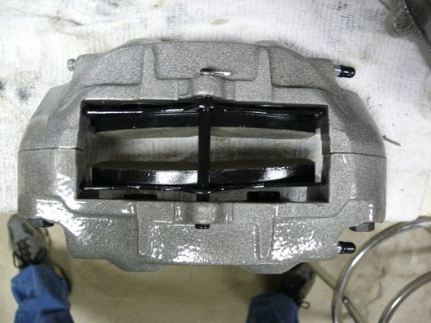 Gray brake caliper with black brake pads