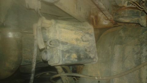 1996 Ford Bronco - A close-up view of an unidentified, mud-covered underbody part of a vehicle.