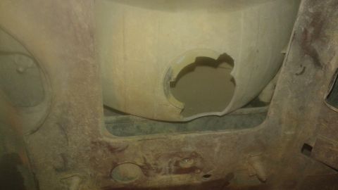 1996 Ford Bronco - The undercarriage of a vehicle shows significant rust and damage to the wheel well.