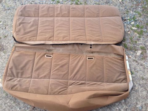 1979 Ford Bronco - Tan velour car seats are shown laid out on a gravel surface.