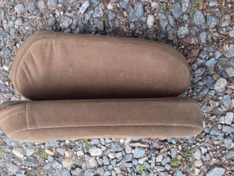 1979 Ford Bronco - Two brown upholstered armrests are shown resting on a bed of gravel.