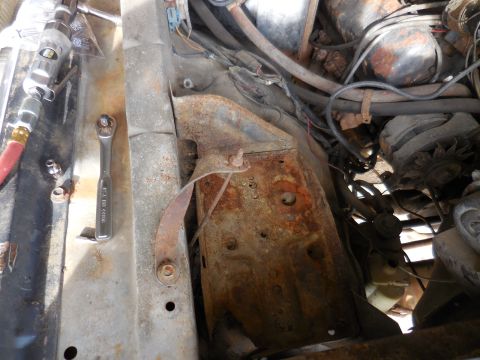1979 Ford Bronco - Close-up view of engine bay components and tools, showing significant rust.