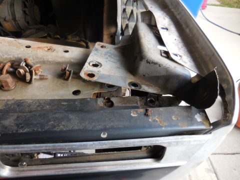 1979 Ford Bronco - Disassembled front end components of a vehicle, with various bolts and brackets visible.