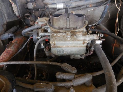 1979 Ford Bronco - Close-up view of a Holley carburetor within a vehicle's engine compartment.