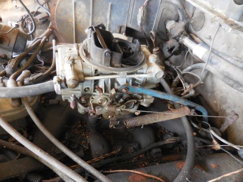 1979 Ford Bronco - Engine carburetor with associated hoses and wiring, viewed from above.