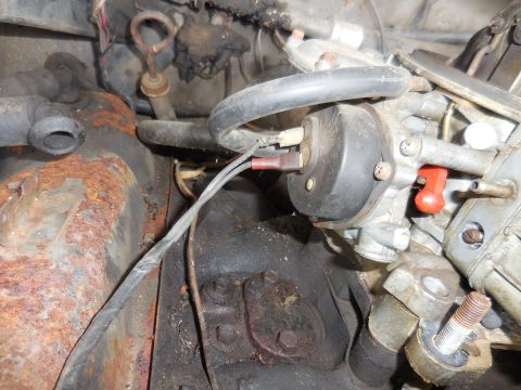 1979 Ford Bronco - Close-up view of engine bay components, including a carburetor and wiring, with visible rust.