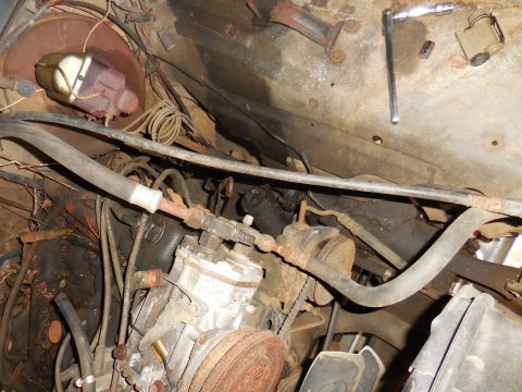 1979 Ford Bronco - Close-up view of various engine components and tools in a vehicle's engine bay.