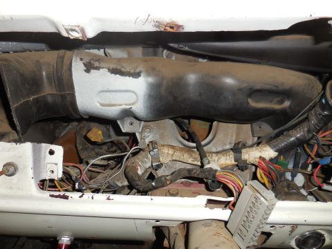 1979 Ford Bronco - A close-up view of the under-dash wiring harness and air ducting of a vintage Ford Bronco. The components are dusty and show signs of age a…