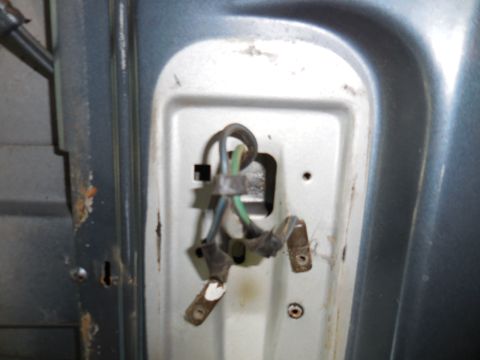 1979 Ford Bronco - Close-up view of the wiring harness connected to a metal panel, likely from the interior of a vehicle. The wiring is bundled and secured wi…