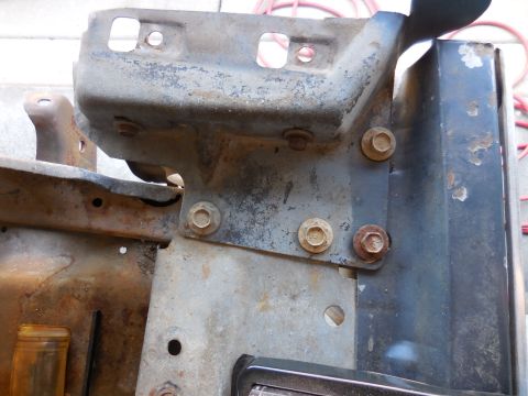 1979 Ford Bronco - This is a close-up view of rusty metal brackets and bolts, likely part of a vehicle's frame or bumper assembly. The components show signifi…