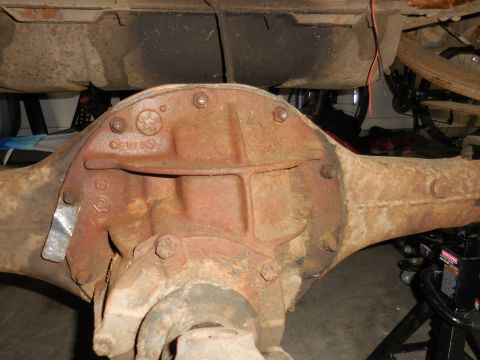1979 Ford Bronco - A heavily rusted Ford rear axle assembly is shown, likely from a 1979 Ford Bronco, with visible casting numbers and a metal identification…