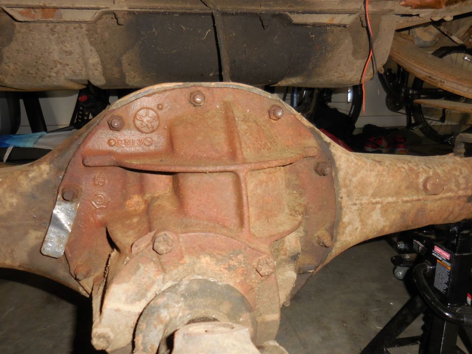 Rusted Ford rear axle assembly with identification tag.