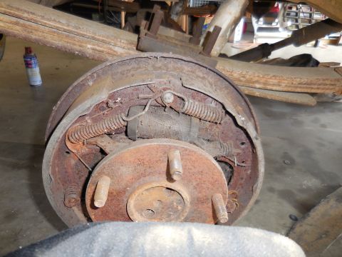 1979 Ford Bronco - Close-up view of a rusty brake drum and associated suspension components, likely from an older vehicle.