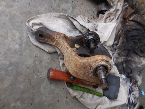 1979 Ford Bronco - A close-up view of a rusty vehicle suspension component, likely a ball joint assembly, resting on a stained cloth.