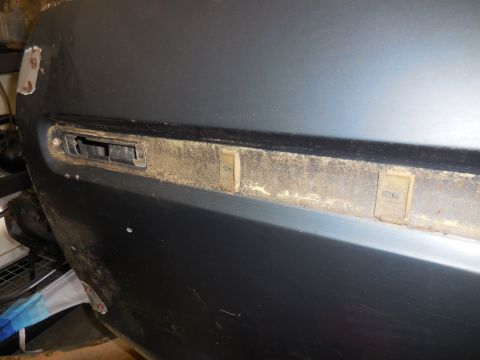 1979 Ford Bronco - Close-up of a vehicle door panel, showing mounting points for trim and clips.