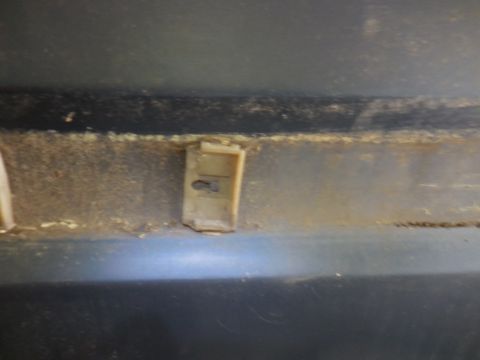 1979 Ford Bronco - A close-up shot shows a plastic clip attached to a dark surface, with visible dirt and grime.