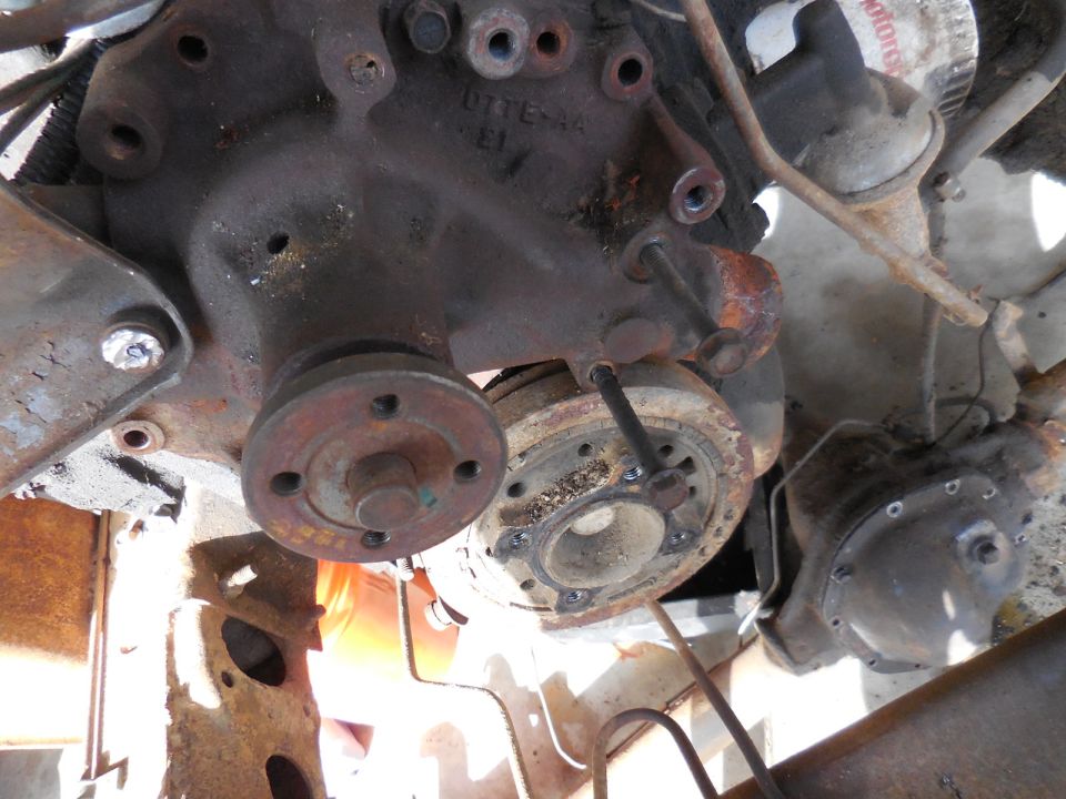 Underside engine view of a rusted 1979 Ford Bronco showing crankshaft pulley and oil filter.