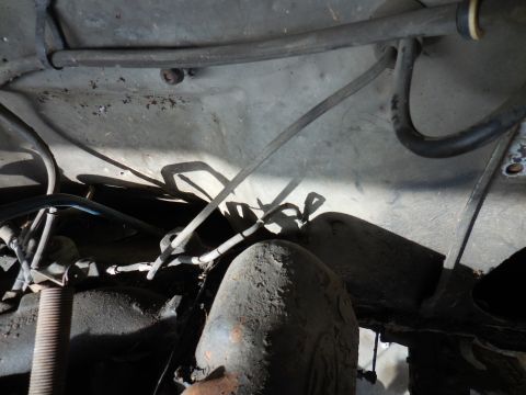 1979 Ford Bronco - This image shows the underside of a vehicle, focusing on various hoses and metal components. The area appears to be part of the engine bay…