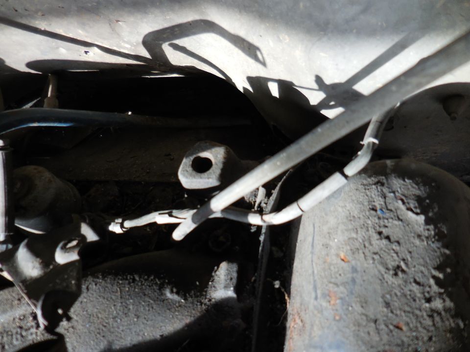 Underside of a vehicle showing brake lines and suspension parts