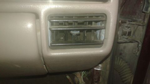 1996 Ford Bronco - A close-up interior shot shows a dusty air vent on the dashboard of a vehicle. The vent has horizontal slats and a chrome trim surrounding…